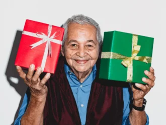 Happy older man holding thoughtful gifts with a smile, showcasing the joy of receiving perfect presents for older men