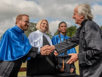 Graduates shaking hands during a graduation ceremony outdoors