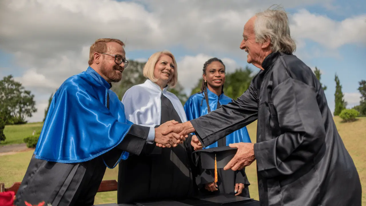 Graduates shaking hands during a graduation ceremony outdoors