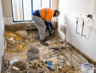 Construction worker renovating a bathroom for seniors, preparing for bathroom upgrades to improve accessibility
