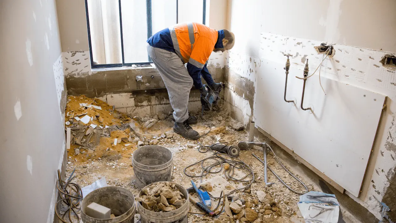 Construction worker renovating a bathroom for seniors, preparing for bathroom upgrades to improve accessibility