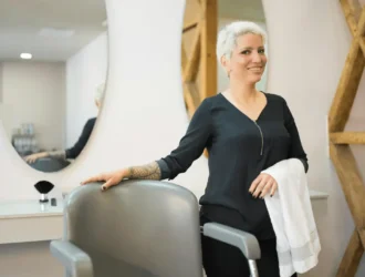 A 50-year-old woman getting a short, trendy haircut in a salon — a stylish hairstyle idea for older women
