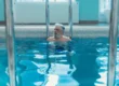 Senior man performing pool workouts for seniors in the water, improving strength and balance