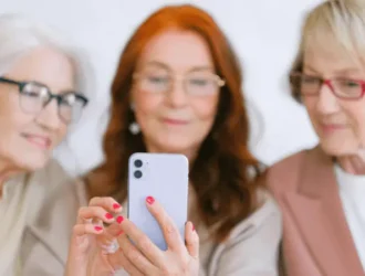 Senior women enjoying using a dating app on their phones, exploring online connections.
