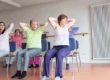 Seniors practicing chair yoga in a class, performing seated exercises to improve posture and flexibility.