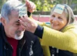 Elderly couple playing a fun word game together with sticky notes on their foreheads, engaging in a memory-boosting and social activity.