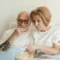 Senior couple watching a movie together at home with popcorn, enjoying streaming services.