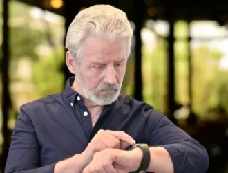 Senior man checking his Apple Watch, highlighting health and safety features for elderly users.