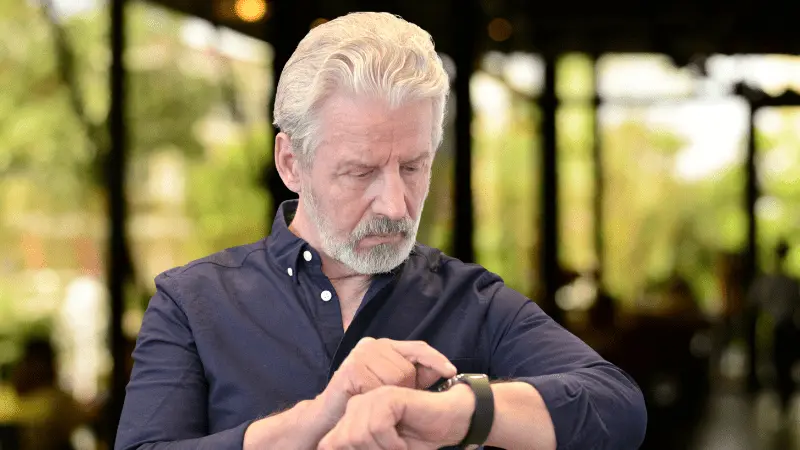 Senior man checking his Apple Watch, highlighting health and safety features for elderly users.