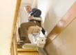 A senior man using a stair lift to move safely upstairs at home, enhancing mobility and independence.