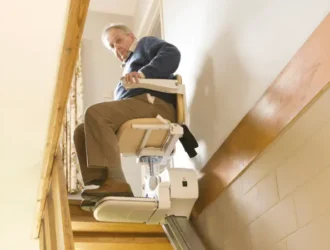 A senior man using a stair lift to move safely upstairs at home, enhancing mobility and independence.