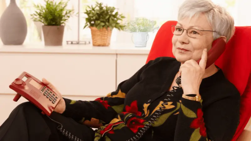Senior woman using a landline phone at home, enjoying a conversation with clear sound and ease